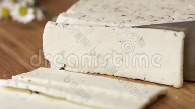 新鲜的白色农家干酪，用切菜板上的刀片切碎香草