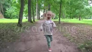 淘气的小女孩在镜头前穿过公园树小巷