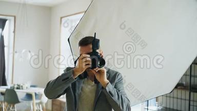 年轻的摄影师在照相馆工作，在数码相机上拍摄模特照片
