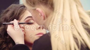 化妆师在眼睛上画黑色眼线