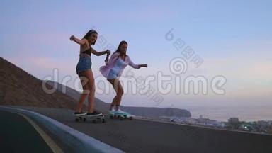 两个女朋友穿着短裤和运动鞋，在<strong>太阳升起</strong>的美丽天空下，在斜坡上骑滑板