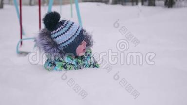一个<strong>小孩</strong>在<strong>冬天</strong>的公园里玩雪.. 躺在白色蓬松的雪上微笑的婴儿。 新鲜的乐趣和游戏