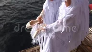 穿着<strong>白衣天使</strong>服装的模特在红海附近的船只上指着。