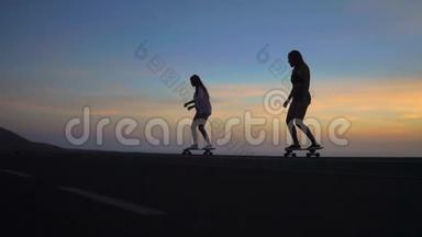 两个女朋友穿着短裤和运动鞋，在<strong>太阳升起</strong>的美丽天<strong>空</strong>下，在斜坡上骑滑板