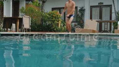 暑假里的年轻人在炎热的晴天跳进蓝色的游泳池里喝点东西。 一个人在空中潜水