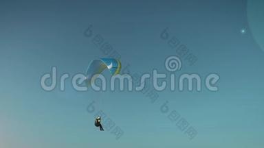 <strong>滑翔伞</strong>。 那个女人在单调的蓝天背景下在<strong>滑翔伞</strong>上飞行。