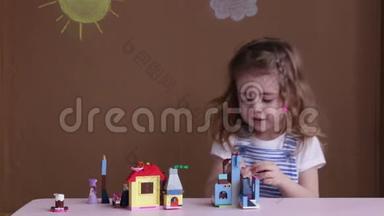 可爱有趣的学龄前小女孩在幼儿园房间里玩建筑玩具积木。