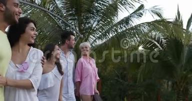 令人兴奋的一群人在酒店的夏季露台上观看热带森林的日落，在度假时与种族朋友混在一起