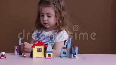 可爱有趣的学龄前小女孩在幼儿园房间里玩建筑玩具积木。