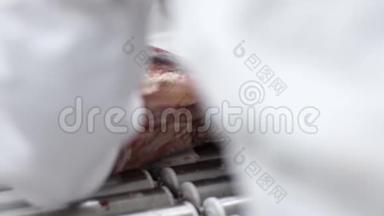 屠夫在屠宰厂用锯条机切生红肉。