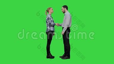 两个年轻人握手在绿色屏幕上<strong>保持沉默</strong>，Chroma键。