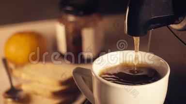 慢动作咖啡机在早餐时在一<strong>杯中倒入</strong>新鲜的浓缩咖啡。