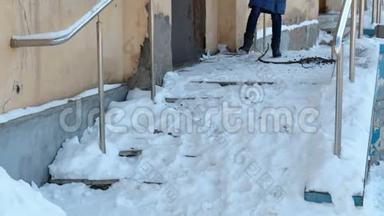 滑的楼梯。 一个穿着蓝色羽绒服从雪梯走下来的面目全非的女人。
