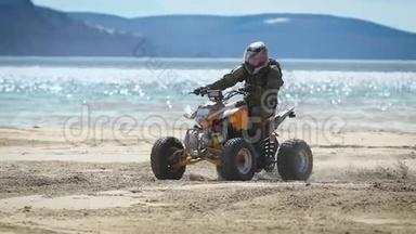 一个戴着头盔的人骑着ATV在海边的沙滩上，一个人很快地转过身来