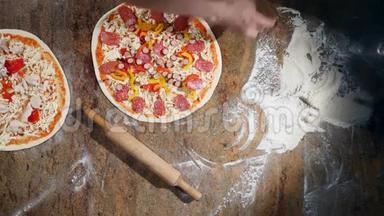 厨师在厨房里把配料放在比萨饼上。披萨概念。食品的生产和运送。顶部