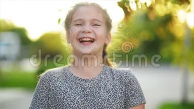 一幅欧洲金发女孩的特写肖像，她的牙齿都在微笑。 阳光明媚的下午快乐的孩子造就了