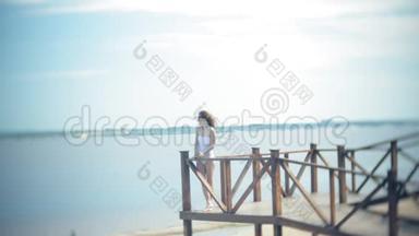 热辣的女孩站在<strong>沙滩上</strong>的桥<strong>上晒太阳</strong>.. 4k.
