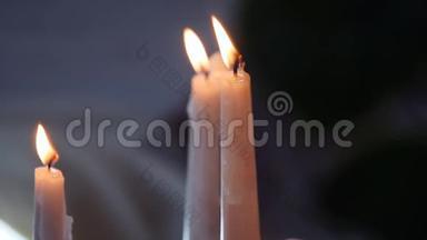 白色的蜡烛平静地燃烧着。 一支蜡烛在聚焦，另一支蜡烛在聚焦