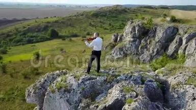 小提琴手在岩石高原上拉小提琴