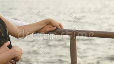 这对夫妇在海的背景下<strong>双手握</strong>在桶上的特写镜头。