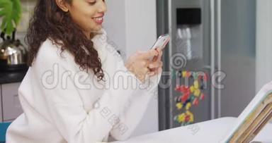 幸福的女人靠在厨房柜台上，用她的手机4K4K