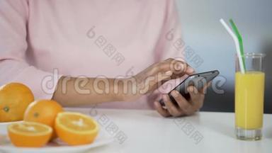 多种族女孩在厨房里使用智能手机，桌上放橘子，医疗保健