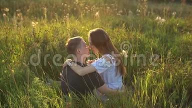 年轻夫妇在田野里接吻。 关于激情和爱的概念