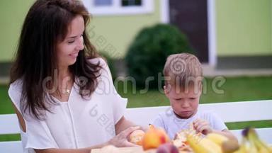 夏天，在花园里。 妈妈和四岁的儿子从橘子皮中清洗。 他们想做新鲜果汁