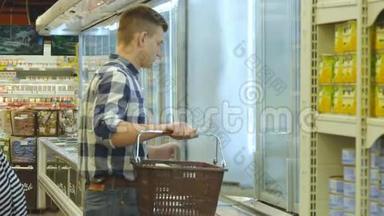 带着购物车的年轻人在冷藏区的超市买奶制品或冷藏食品