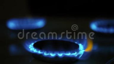 用燃烧的气体环烹饪。 在黑暗中有蓝色和黄色火焰的<strong>煤气灶</strong>。