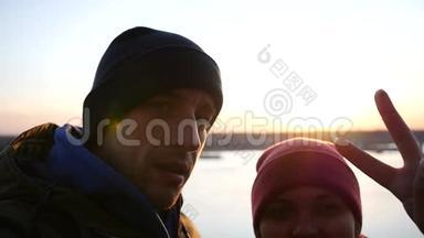 少年夫妇在秋日日落的背景下，在河边拍摄，在室内展示