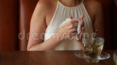 女孩在咖啡馆喝茶前用湿餐巾纸擦手。 4k. 慢镜头拍摄。
