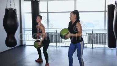 两个女人正在健身，把球举<strong>到头</strong>上。