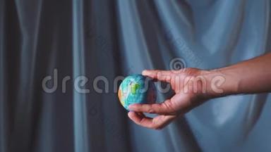 这只手握着地球仪，把地球抛起来. 世界掌握在你手中。 慢动作