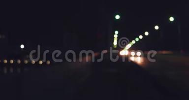 夜晚天桥上的车灯散焦。 繁忙街道交通的夜间镜头
