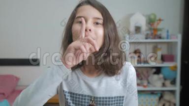 小少女手势手指安静.. 慢动作视频。 女孩把手指放在嘴唇上说嘘。 少女少女少女