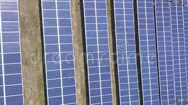 太阳能电池板的空中景观农场太阳能电池与阳光。 无人机飞行飞越太阳能电池板领域，可再生绿色