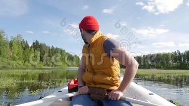 年轻的混合种族白种人，留胡子的希普斯特男子划<strong>船充气船</strong>与木桨在湖上。 HD慢动作生活方式