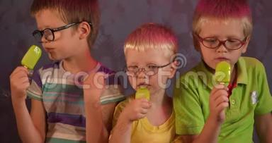 有趣的孩子兄弟戴眼镜吃绿色开心果冰淇淋的棍子。 儿童为视障儿童上学。