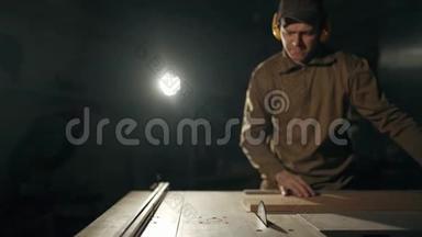 一个专业的木匠正在用一个特殊的<strong>电锯</strong>来切割一个长方形的木条。 在办公桌前工作