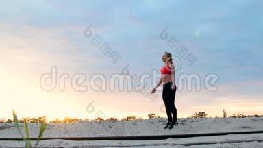 美丽，<strong>苗</strong>条的年轻女子从事健身，跳绳，黎明时，在一个货鹤附近，在沙石场