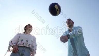 男孩和女孩在蓝天下玩<strong>排球</strong>游戏。