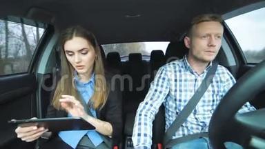 男人在打电话，女孩在开车时用平板电脑