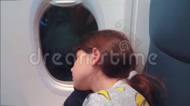 <strong>航空飞机</strong>概念。 坐在窗边的小女孩睡在飞机上。 晚上乘飞机