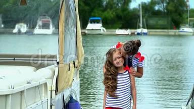 两个姐妹在水的码头上互相拥抱。 两个姐妹在游艇上玩得很开心