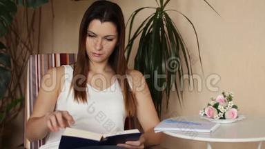 年轻漂亮的女人<strong>看书</strong>和做笔记。 坐在椅子上<strong>看书</strong>的女人。