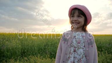 肖像微笑的女孩，快乐的孩子背景花田，女孩子在巴拿马，帽子在头上，孩子看着