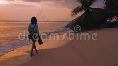 背着背包在海滩上<strong>行</strong>走的女人，在夕阳的灯光下，<strong>稳稳</strong>地拍着