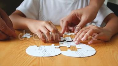 亚洲小女孩和家人一起玩拼图游戏，妈妈选择专注于手浅的领域