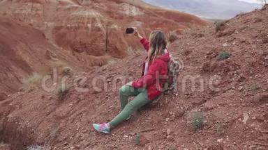 女游客在相机智能手机上制作<strong>照片</strong>。 红色的山脉和红色的地球就像<strong>火星</strong>一样。